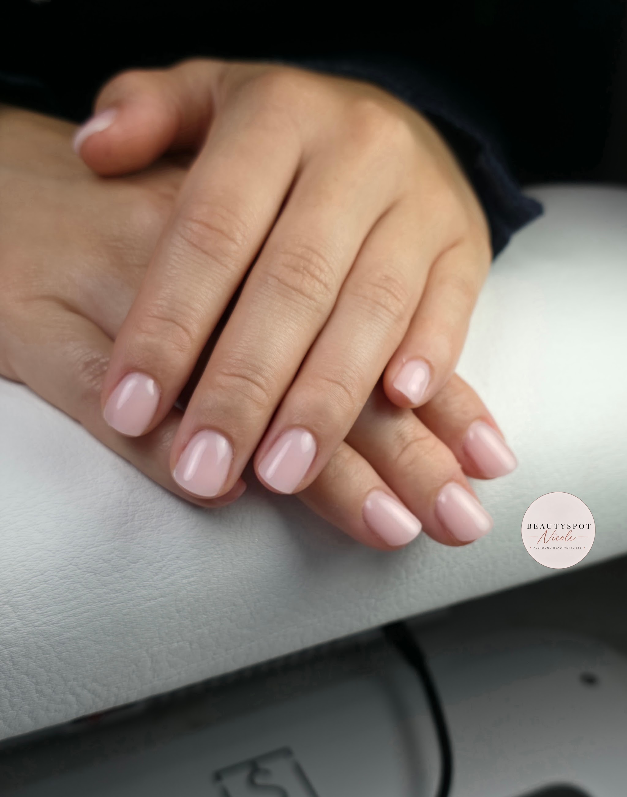 Zachtroze natuurlijke nagels op het armkussen