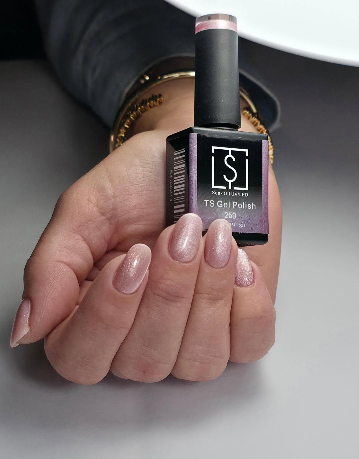 Glitternagels met een flesje TS Gel Polish in de hand